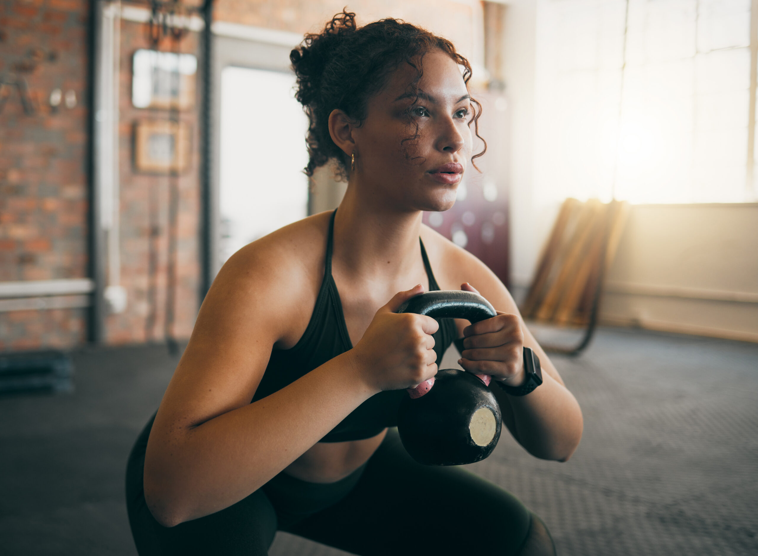 Woman performing a kettlebell goblet squat during a metabolic conditioning workout, building strength and endurance in a single session.